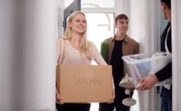 Group Of College Student Carrying Boxes Moving Into Accommodation Together