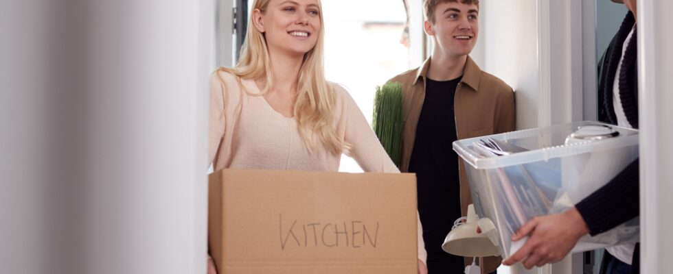 Group Of College Student Carrying Boxes Moving Into Accommodation Together